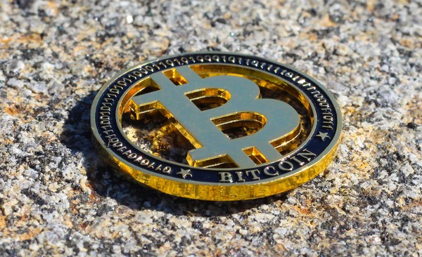 Bitcoin coin lying on granite stone