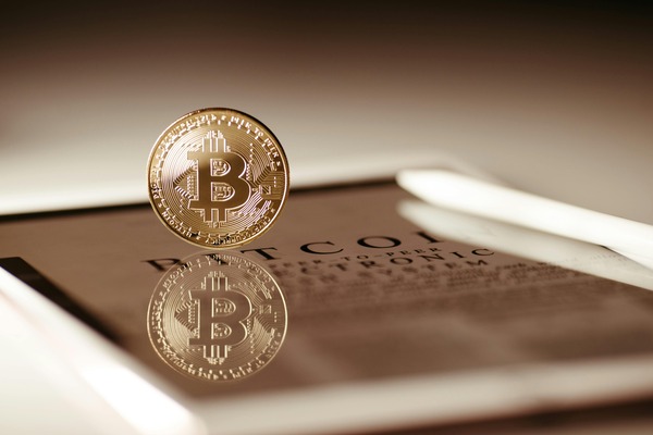 Bitcoin coin reflected on a tablet screen