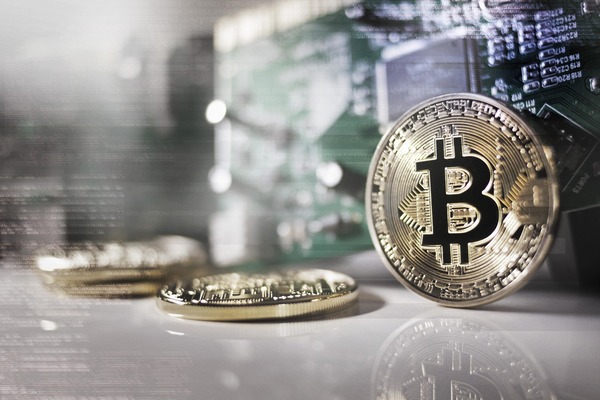 Bitcoin coin standing on a reflective surface