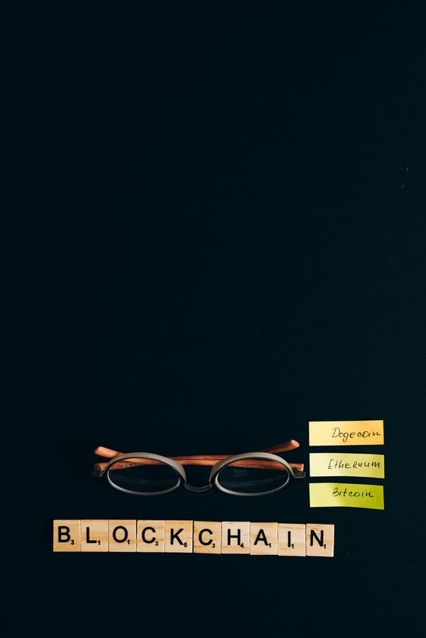 Blockchain letters and glasses on a dark desk