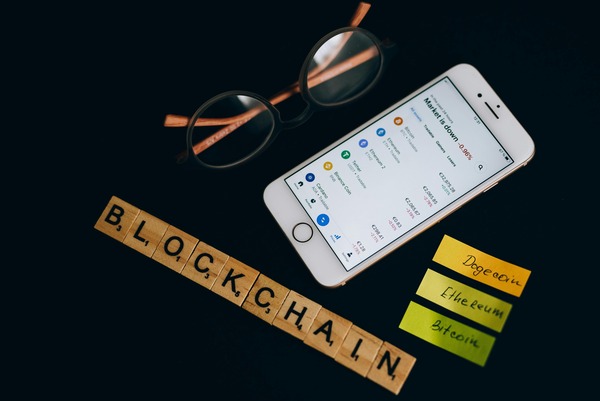 Blockchain letters beside a smartphone with notes