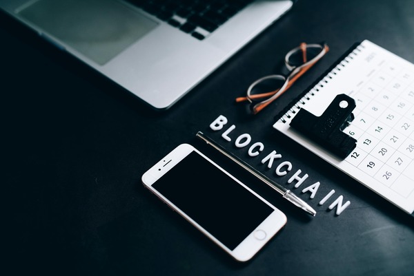 Blockchain letters with a smartphone and notebook
