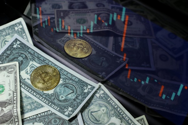 Dollar banknotes and coins over a candlestick chart
