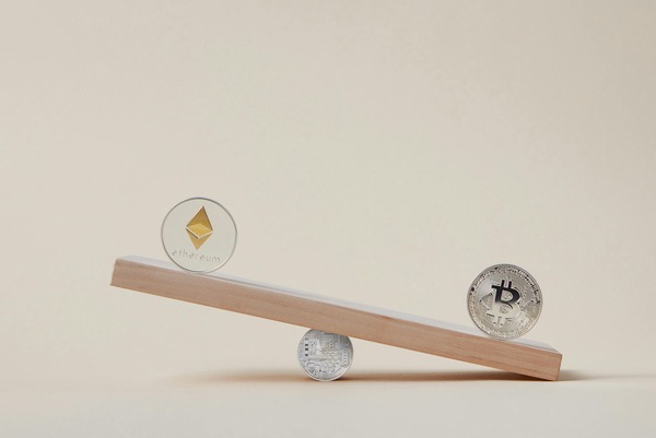 Ethereum and Bitcoin coins balancing on a seesaw