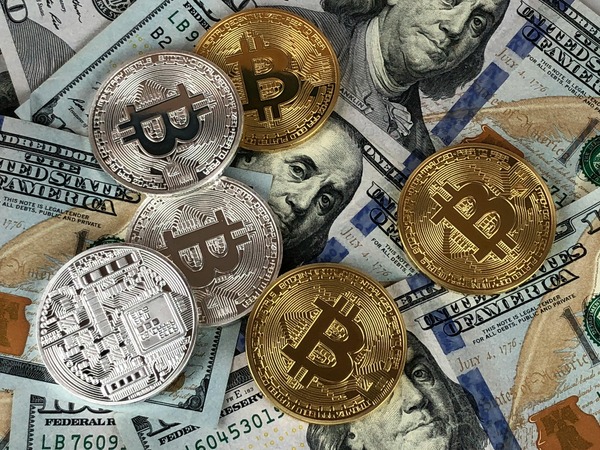 Gold and silver Bitcoin coins on dollar bills