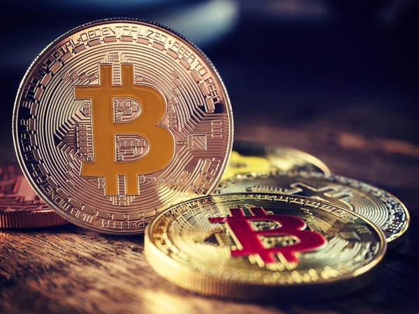 Gold Bitcoin coins on a wooden table
