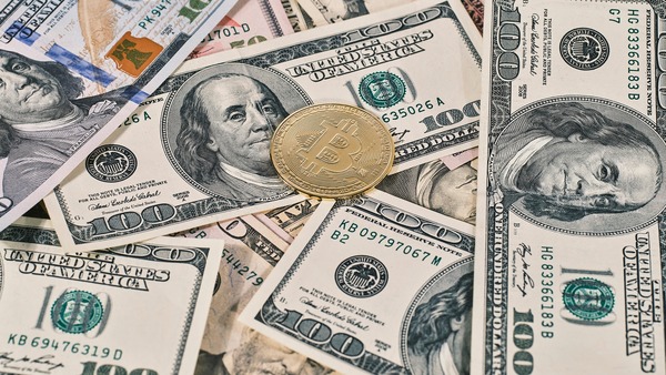 Gold coin on a pile of US dollar banknotes