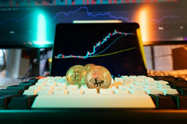 Gold coins on a keyboard with a price chart screen