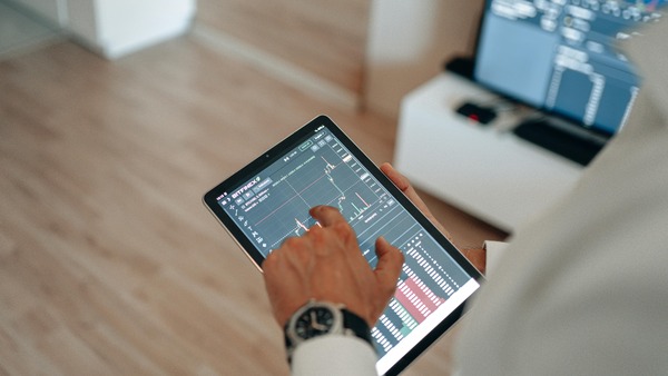 Hand using a trading app on a tablet