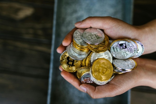 Hands holding a pile of crypto coins