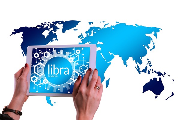 Hands holding a tablet over a world map
