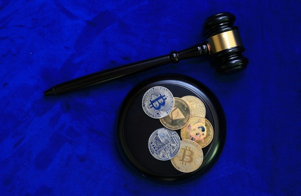 Judge gavel with crypto coins on a blue background