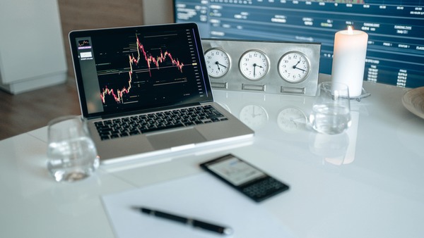 Laptop with a price chart and world clocks on a desk