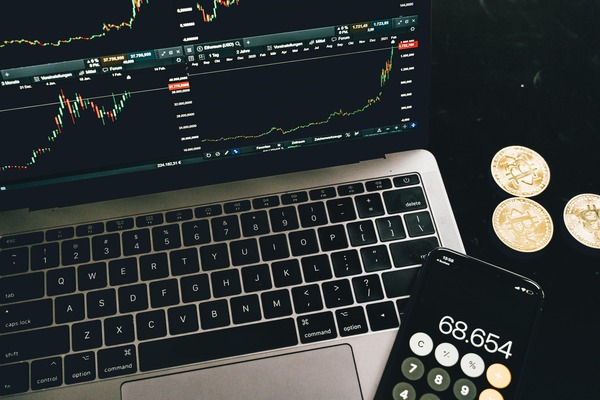 Laptop with charts a calculator and coins