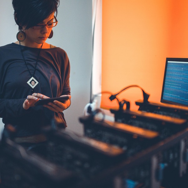 Person holding a phone near a computer setup