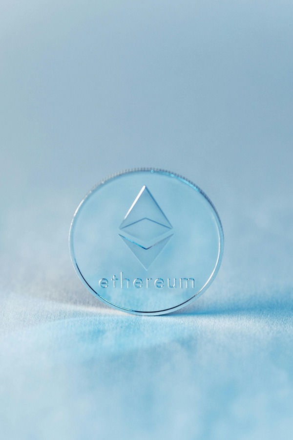 Transparent Ethereum coin on a light blue background